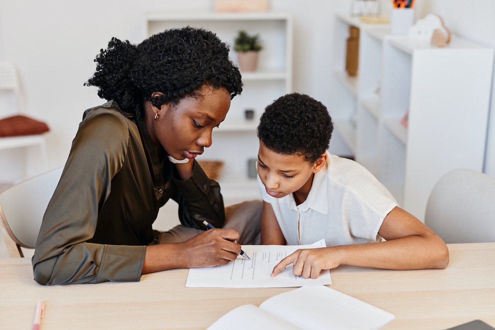 Black Female Tutor Helping Student at Home