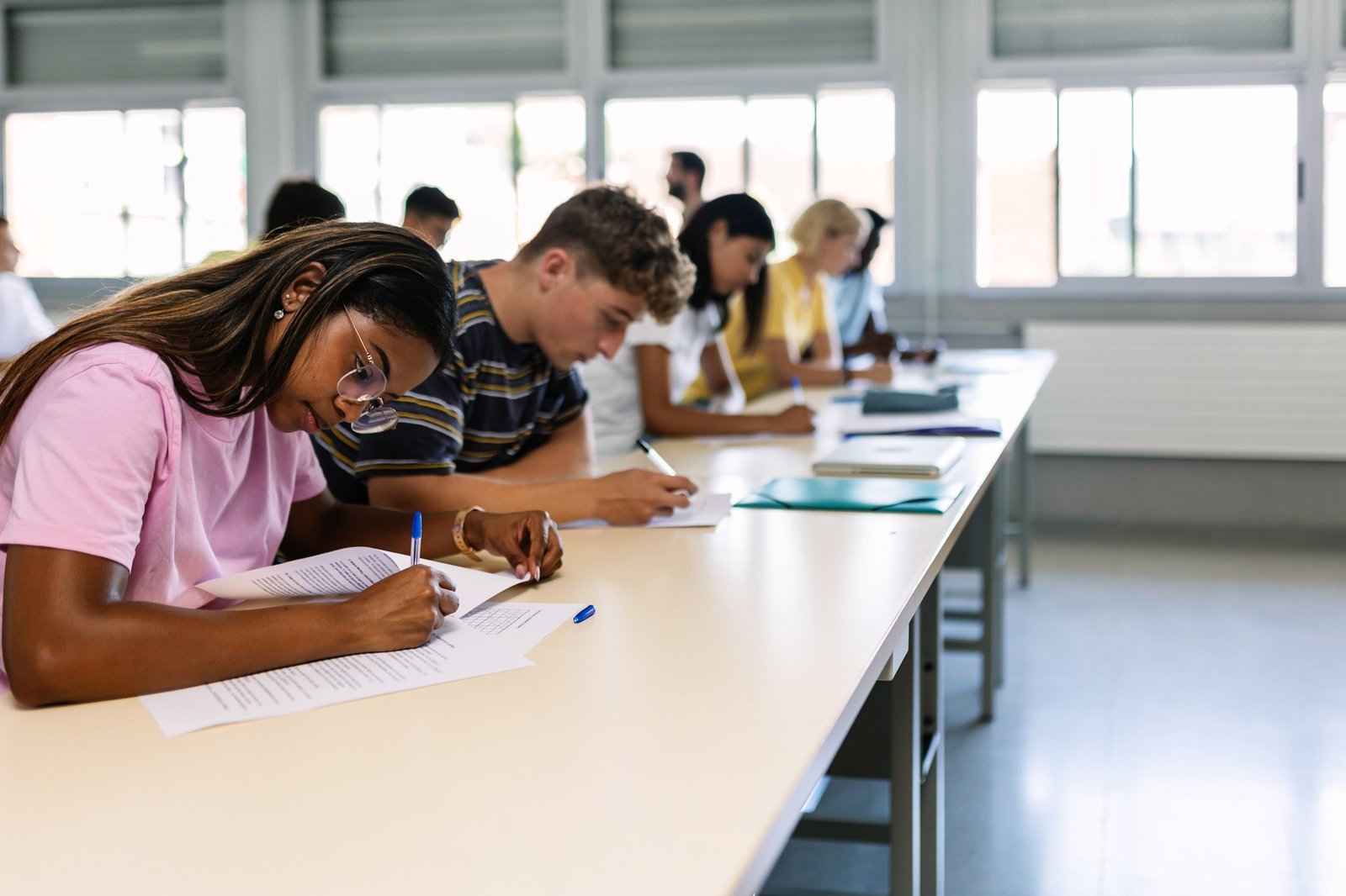 Group of high school students doing an exam in classroom